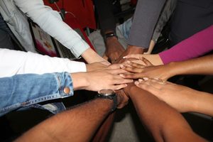 personnes de différentes origines unissant leurs mains en signe de solidarité